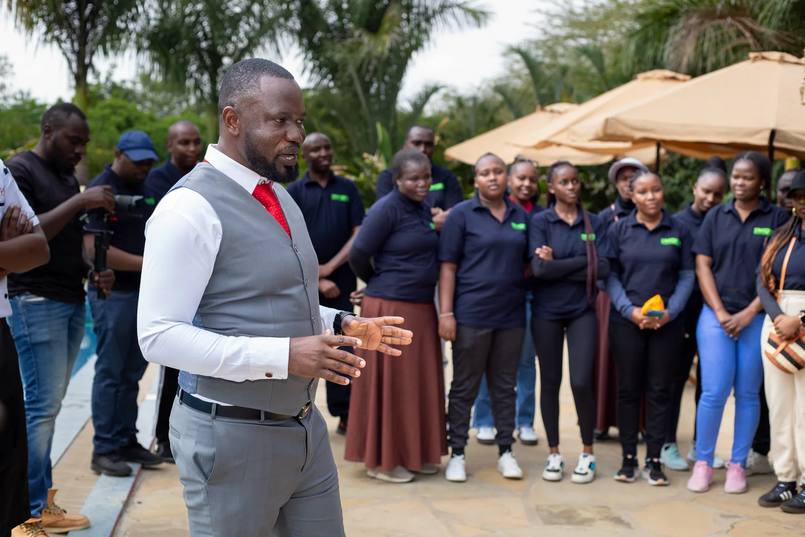 A man addressing a group gathered outdoors