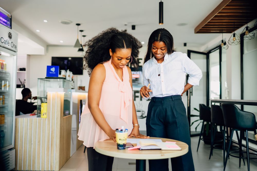 Two women collaborating over notes in Lagos